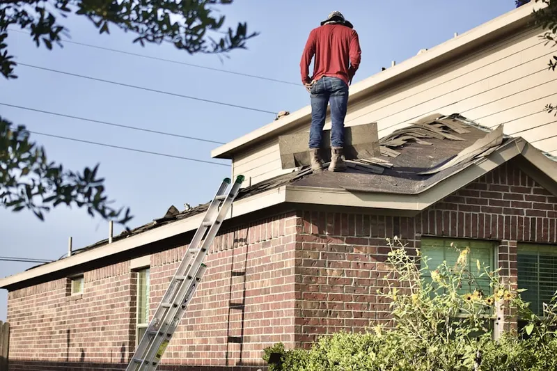 Professional roofer working on a residential roof in Moss